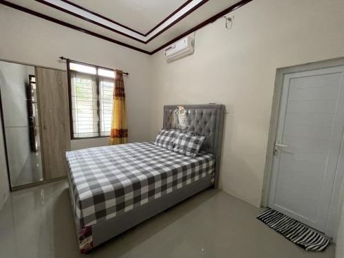 a bedroom with a bed in a room with a window at Mawar Homestay in Banda Aceh