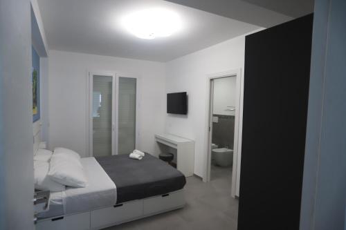 ein Schlafzimmer mit einem Bett und ein Badezimmer mit einem Waschbecken in der Unterkunft Casa Vacanza Da Angela & Corrado in Pozzallo