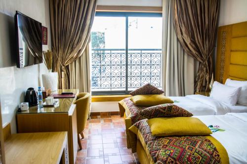 Cette chambre comprend 2 lits et une fenêtre. dans l'établissement Aralia Boutique Hôtel, à Rabat