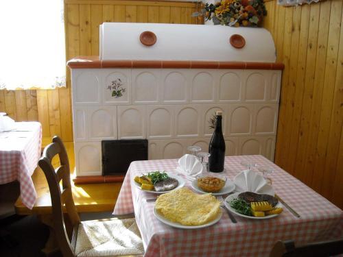 a table with plates of food and a bottle of beer at Al Tajol in Lamon