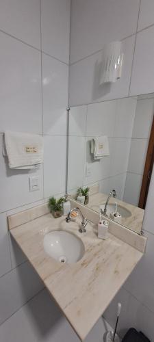 a bathroom with a wooden counter with a sink at Porto do Sol - Chalé 07 in Pipa