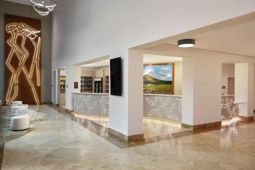 a lobby with white walls and a painting on the wall at DoubleTree by Hilton Managua in Managua