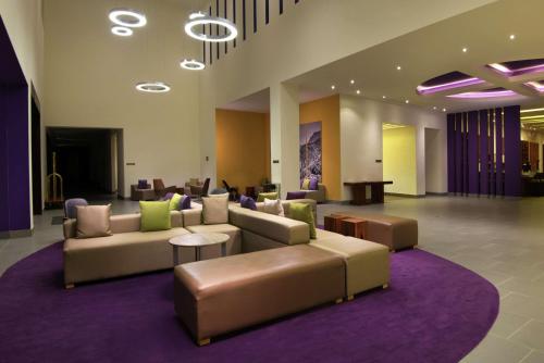 a lobby with couches and a purple rug at Hilton Garden Inn Monterrey Airport in Monterrey