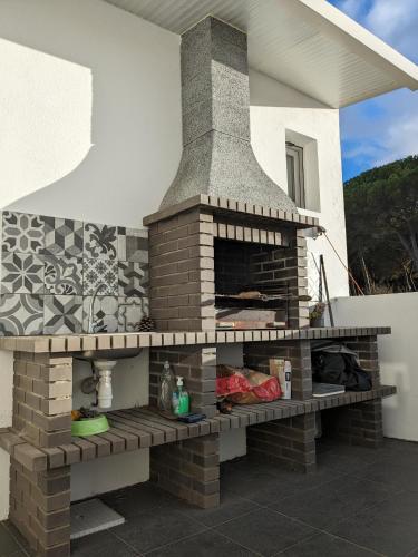 a brick fireplace on the side of a house at Small house with private park and yard in Terrugem