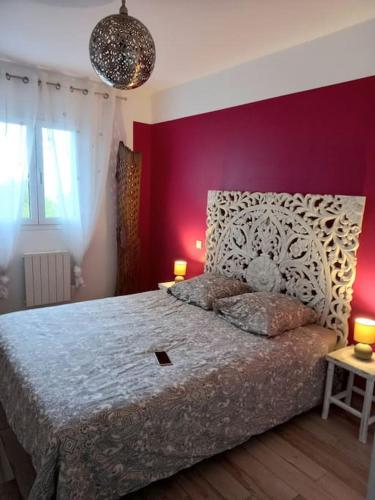 une chambre avec un grand lit avec un mur rouge dans l'établissement appartement de standing T2 l'île rousse vue mer résidence paolina, à LʼÎle-Rousse