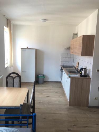 eine kleine Küche mit einem Tisch und einem Kühlschrank in der Unterkunft Apartment für Monteure in Leipzig