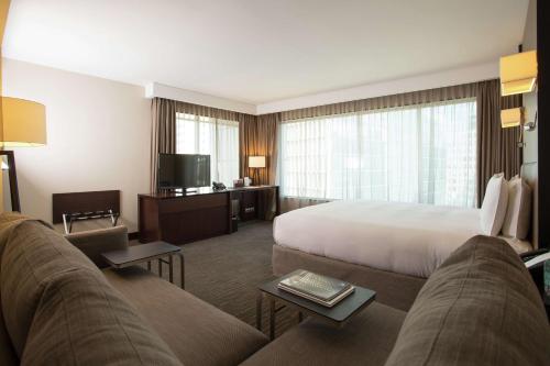 a hotel room with a bed and a couch at DoubleTree by Hilton Santiago - Vitacura in Santiago