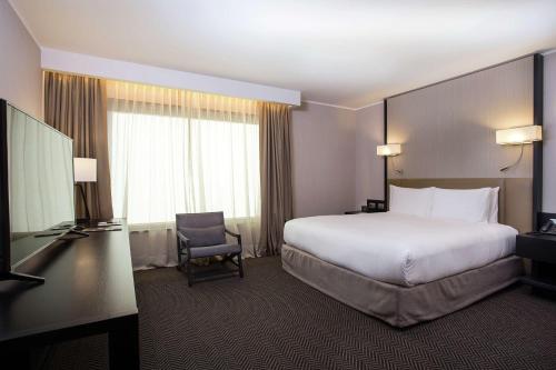 a hotel room with a large bed and a television at DoubleTree by Hilton Santiago - Vitacura in Santiago