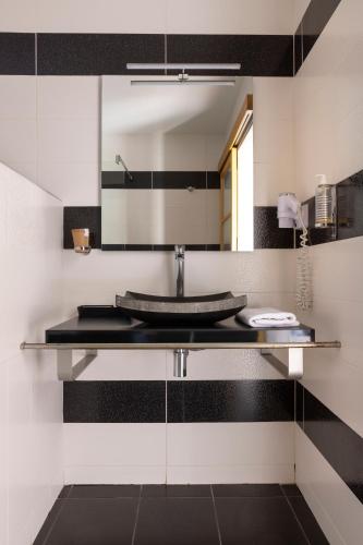 une salle de bain avec un lavabo et un miroir dans l'établissement Hostellerie de la Renaissance, à Argentan