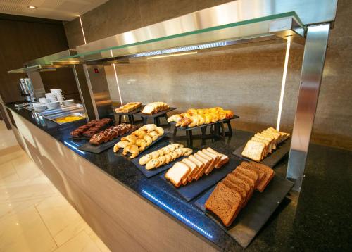 Una línea de buffet con muchos tipos diferentes de comida. en Hilton Garden Inn Santiago Del Estero - HILTON HOTELS, en Santiago del Estero