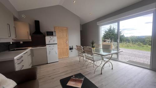 une cuisine avec une table et une cuisine avec une fenêtre dans l'établissement Gîte 4/6 personnes La mélodie du bonheur, à Habas