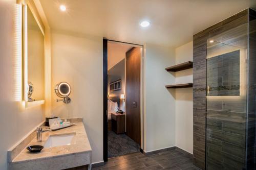 La salle de bains est pourvue d'un lavabo et d'une douche. dans l'établissement Hampton Inn & Suites by Hilton Salamanca Bajio, à Salamanca