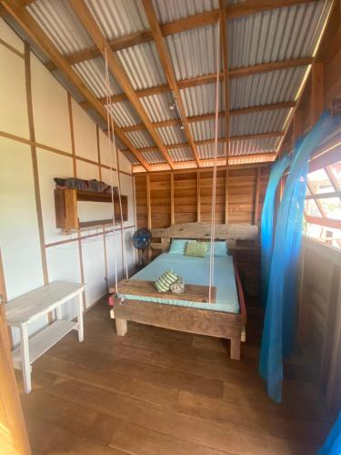 a bed in a room with a swing at Life is Good in Bocas del Toro