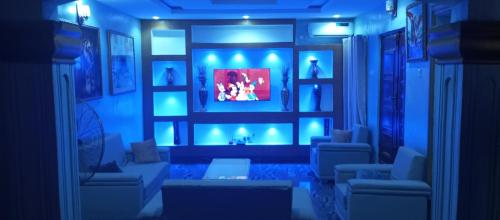 a living room with a fireplace and blue lights at De-Convenant Apartment in Abuja