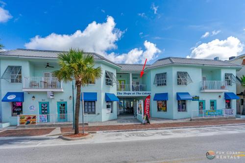 een gebouw met een palmboom ervoor bij Mermaid Themed Apartment with Private Balcony ON Flagler Avenue! Stroll to the Beach! in New Smyrna Beach