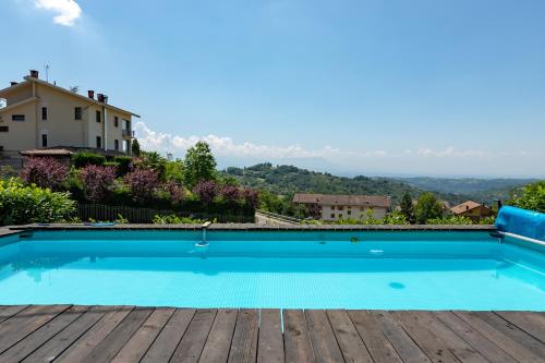 a swimming pool on top of a house with a wooden deck at La Tana dello Scoiattolo - Adults Only in Murazzano