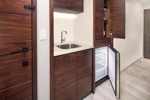 a small kitchen with wooden cabinets and a sink at Hilton Grand Vacations Club La Pacifica Los Cabos in Cabo San Lucas