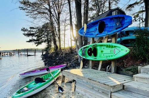 three kayaks are parked on a dock next to the water at Long Cove Resort and Marina in Charlotte