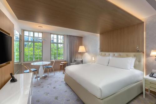 a bedroom with a large white bed and a table at Gran Hotel Costa Rica, Curio Collection By Hilton in San José