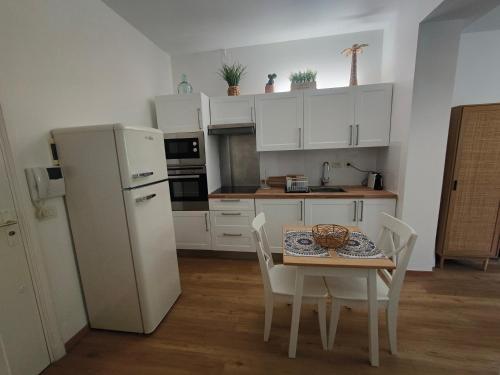 een keuken met een tafel en een witte koelkast bij Studio Cap Martin in Roquebrune-Cap-Martin