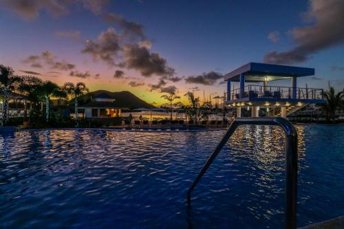 a swimming pool at a resort at sunset at Harbor Club St Lucia, Curio Collection by Hilton in Gros Islet