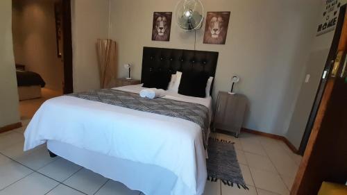 a bedroom with a large bed with white sheets at Kadichueni Guest House in Zeerust