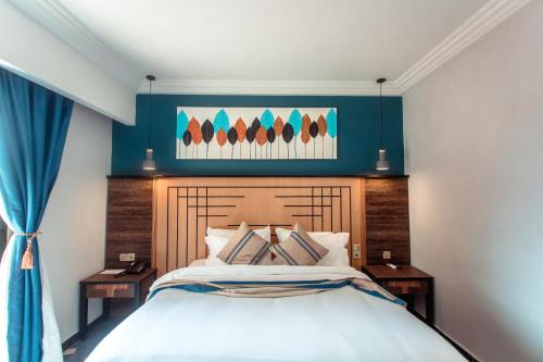 1 dormitorio con 1 cama grande y pared azul en Marcsons Hotels and Resorts en Limbe