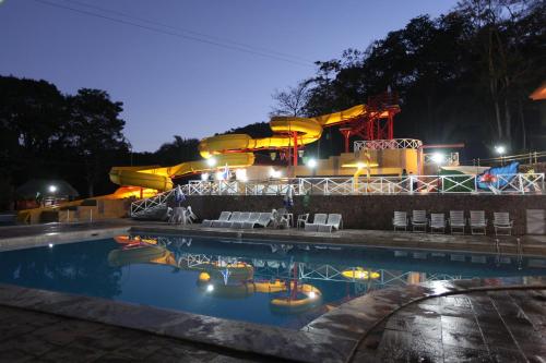 una piscina frente a un parque acuático por la noche en Hotel Mato Grosso Águas Quentes, en Sucuri