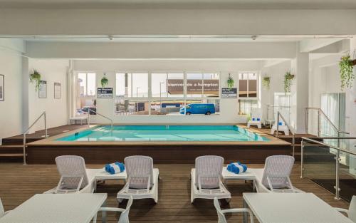 uma piscina com cadeiras e uma piscina em Hampton Inn By Hilton Tijuana em Tijuana