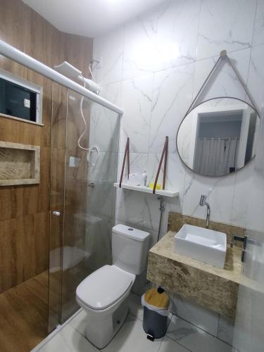 a bathroom with a toilet and a shower and a sink at Casas no Condomínio Dunas Residence - Santo Amaro do MA in Santo Amaro
