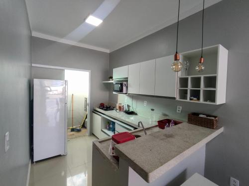 a kitchen with white cabinets and a counter top at Condomínio Dunas Residence - Casa 7 e Casa 10 - Santo Amaro - MA in Santo Amaro