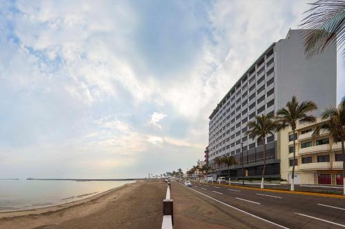a building on a beach next to the ocean at DoubleTree by Hilton Veracruz in Veracruz
