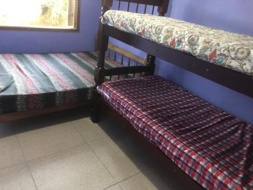 deux lits superposés côte à côte dans une pièce dans l'établissement Casa de praia Boracéia, à Bertioga
