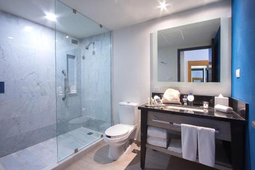 ein Bad mit einer Dusche, einem WC und einem Waschbecken in der Unterkunft DoubleTree by Hilton Veracruz in Veracruz