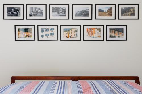 un groupe d'images encadrées sur un mur au-dessus d'un lit dans l'établissement Casamia Juliette, à Valsolda