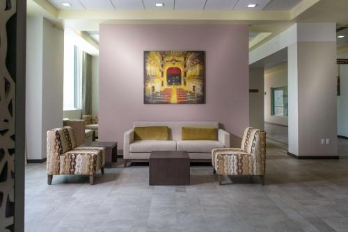 a lobby with a couch and two chairs and a painting at Hampton Inn Zacatecas in Zacatecas