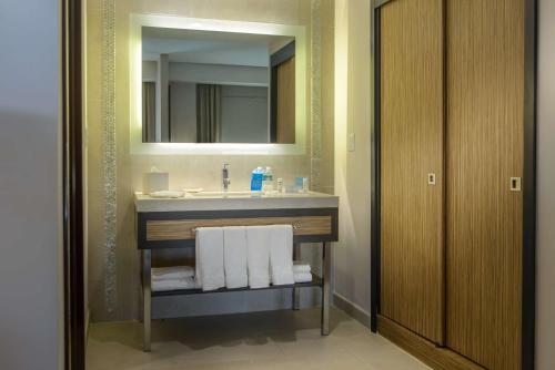 La salle de bains est pourvue d'un lavabo et d'un miroir. dans l'établissement Hampton Inn Zacatecas, à Zacatecas