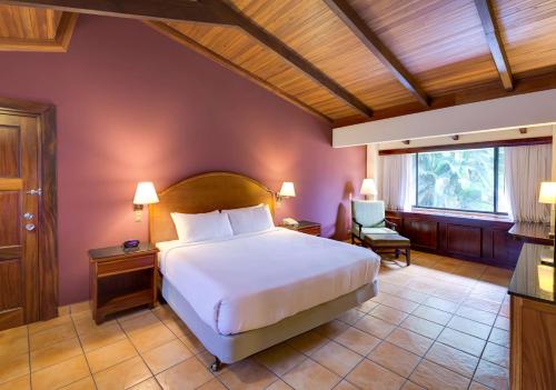 een slaapkamer met een groot bed en een raam bij Hilton Cariari DoubleTree San Jose - Costa Rica in San José