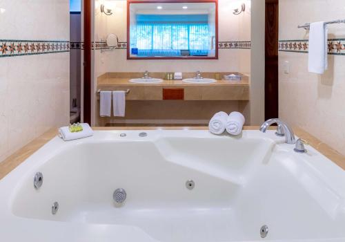 La salle de bains est pourvue d'une grande baignoire blanche et de 2 lavabos. dans l'établissement Hilton Cariari DoubleTree San Jose - Costa Rica, à San José