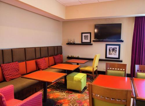 a restaurant with tables and chairs and a flat screen tv at Hampton Inn Torreon Airport-Galerias in Torreón