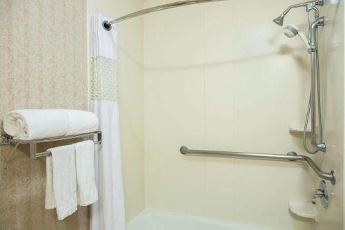 a bathroom with a shower and a bath tub with towels at Hampton Inn Torreon Airport-Galerias in Torreón