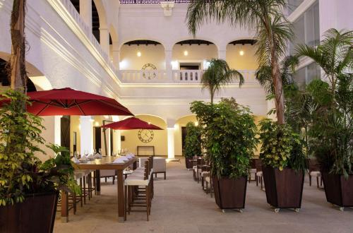 a restaurant with tables and chairs and palm trees at Doubletree By Hilton Toluca in Toluca