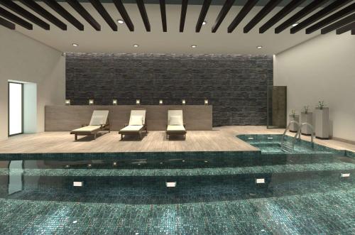 a lobby with a pool with chairs and a table at Doubletree By Hilton Toluca in Toluca