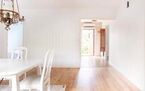 a white dining room with a white table and chairs at By The Bay room in a shared villa in Gothenburg