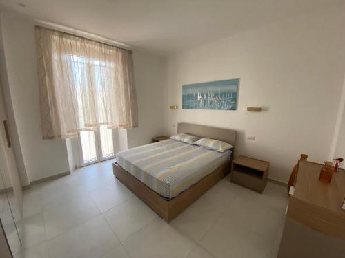 - une chambre avec un lit et une grande fenêtre dans l'établissement AleVale apartment 450mt mare, à Grottammare