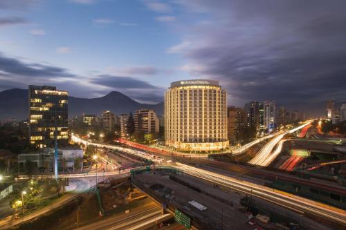 une ville de nuit avec des bâtiments et une autoroute dans l'établissement DoubleTree by Hilton Santiago Kennedy, Chile, à Santiago