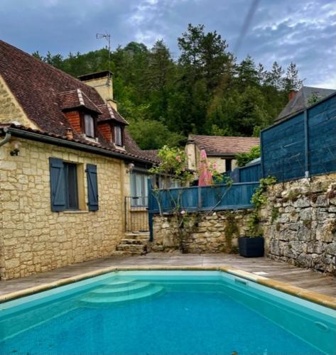 une grande piscine bleue à côté d'une maison dans l'établissement Les Paroules - Luxury Dordogne - Holiday Farmhouses., à Saint-Cybranet