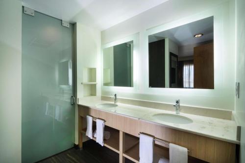 a bathroom with two sinks and two mirrors at Hampton Inn by Hilton Silao-Aeropuerto, Mexico in Silao