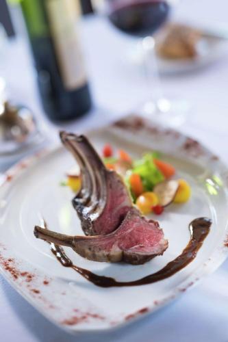 a piece of meat on a plate with vegetables at Hilton Moorea Lagoon Resort & Spa in Papetoai