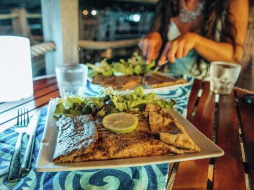 a table with a plate of food on a table at Hilton Moorea Lagoon Resort & Spa in Papetoai